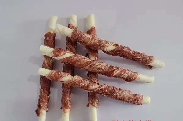 Rawhide sticks wrapped in duck meat, shown against a white background