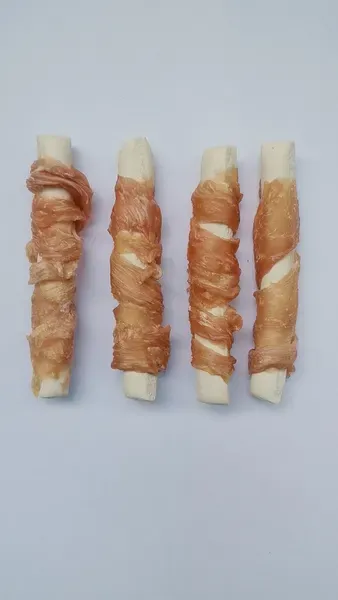 Four chicken-wrapped rawhide sticks laid in a row