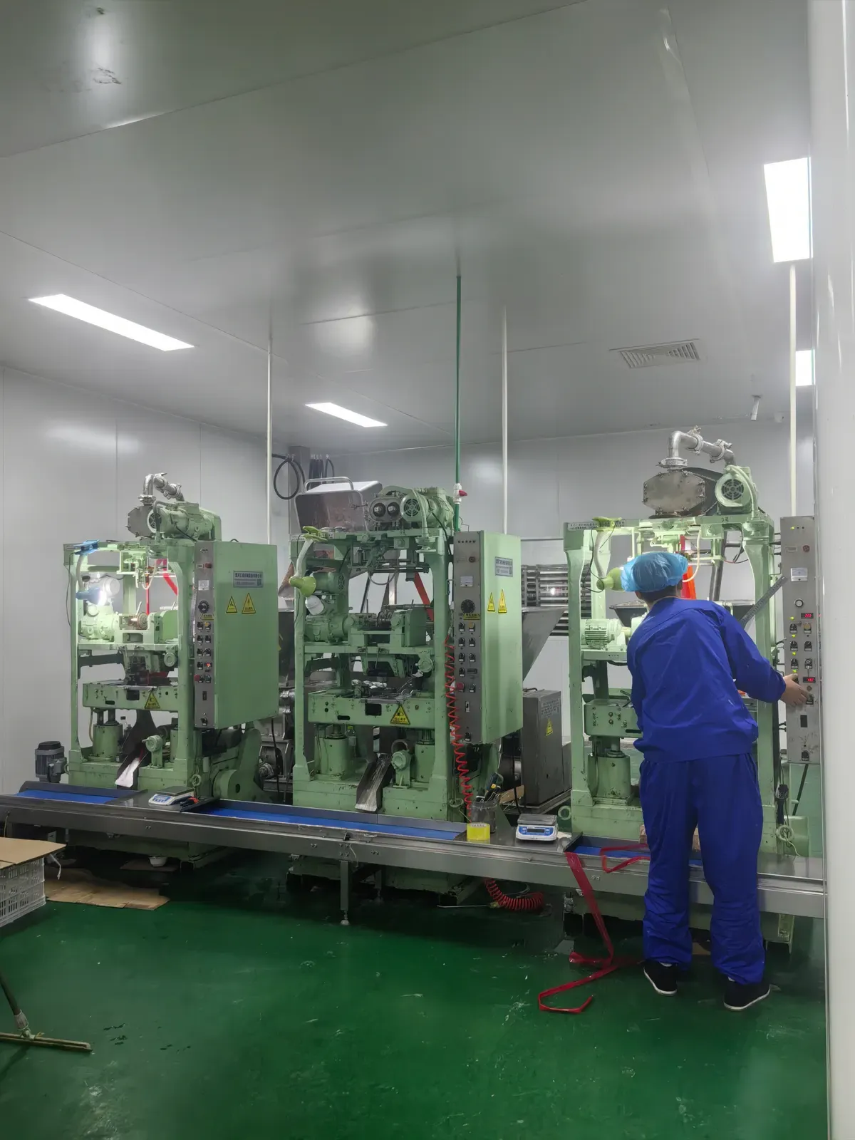 Operator in protective clothing working at vertical form-fill-seal packing machines