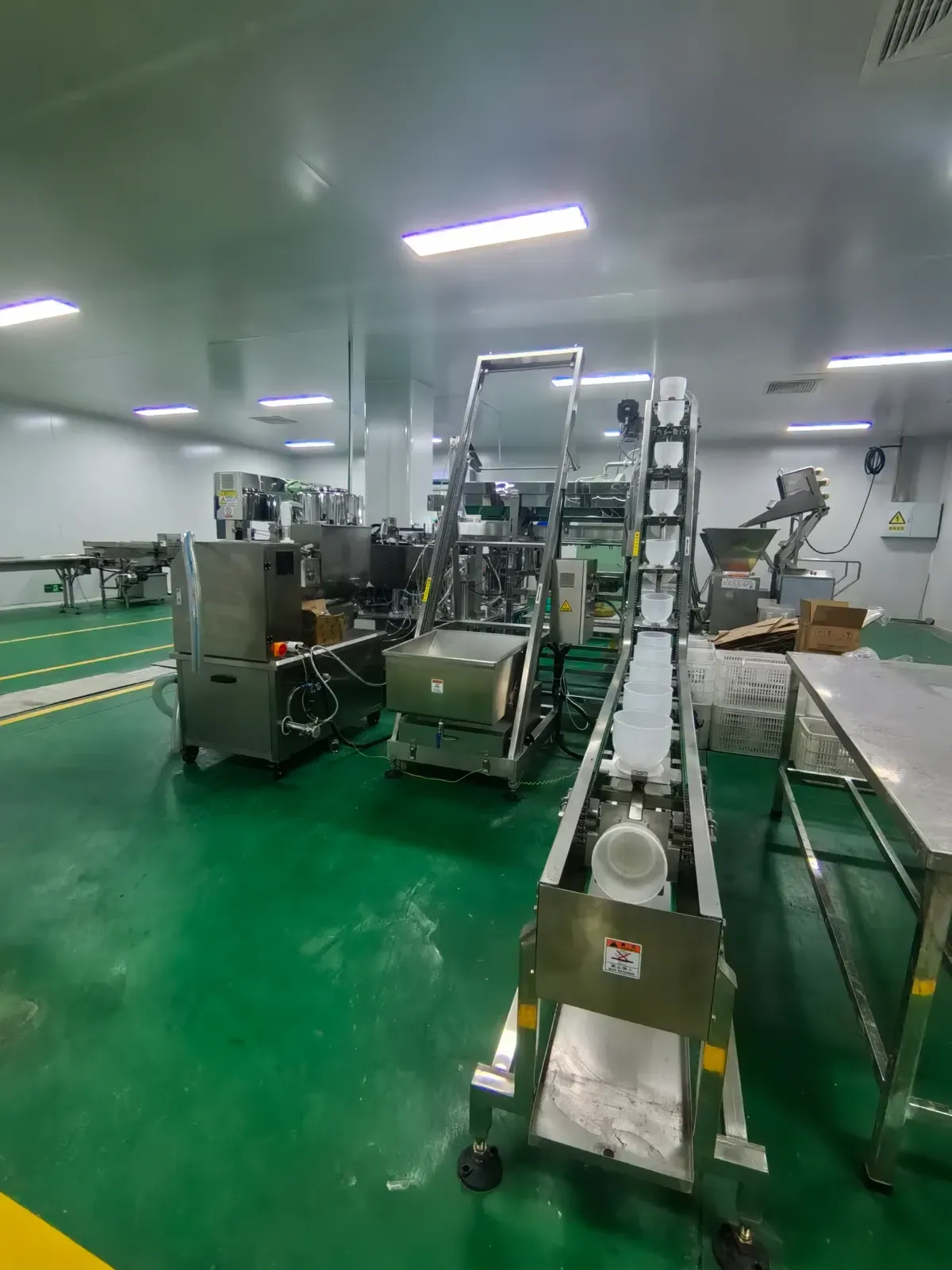 Production workshop with conveyors and stainless steel processing equipment