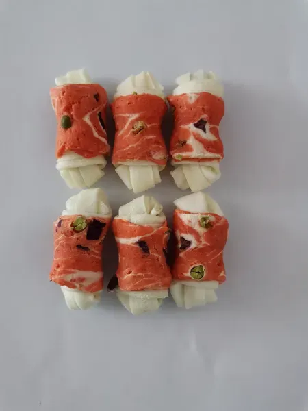 Knotted rawhide bones wrapped in red meat, arranged in two rows